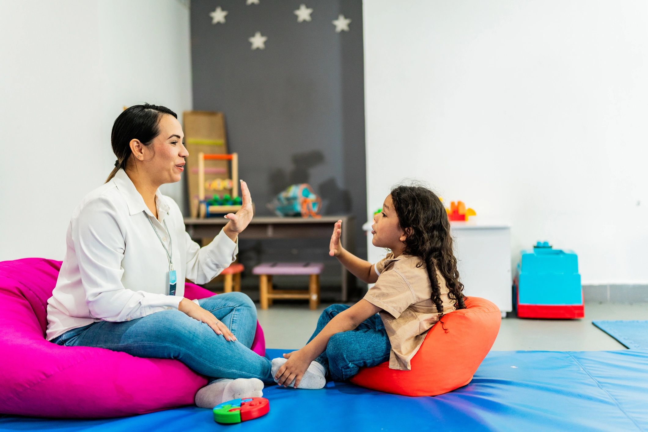 Psychotherapist speaking with a child in a playroom