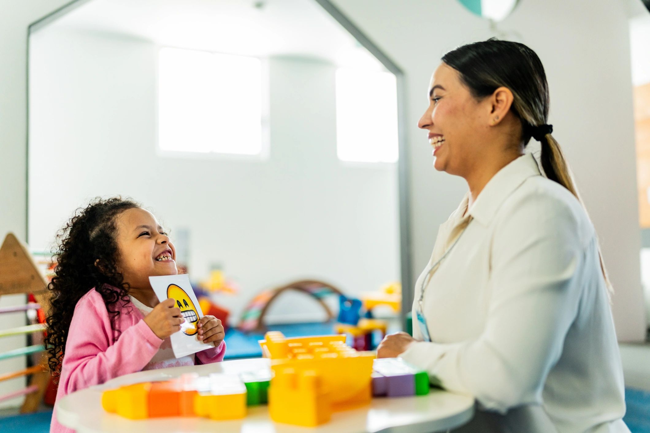 Therapist playing a board activity with a child during therapy at a clinic